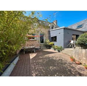 een achtertuin van een huis met een patio bij Spacieuse maison avec piscine in Plédran