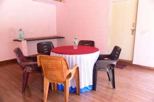 a red and white table with chairs in a room at Ganav home stay in Chikmagalūr