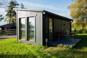 un pequeño cobertizo con una mesa de picnic en el césped en RiverView Cozy Cabins in Jurmala with fishing opportunity, en Jūrmala