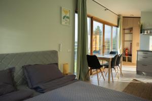 Un dormitorio con una cama y una mesa y sillas. en RiverView Cozy Cabins in Jurmala with fishing opportunity, en Jūrmala