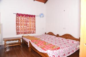 a bedroom with a bed and a window at Ganav home stay in Chikmagalūr