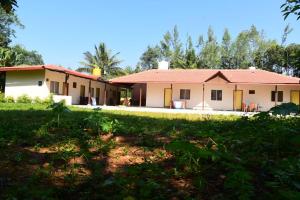 a house with a red roof and a yard at Ganav home stay in Chikmagalūr
