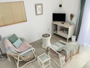 a living room with two chairs and a television at 87 on Sunbird B in Langebaan +2 photos