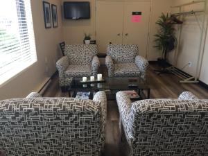 a living room with three couches and a coffee table at Coastal Inn Moncton/ Dieppe in Moncton