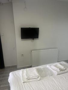 een bed met twee witte handdoeken erop en een tv aan de muur bij Şişli Suites - Room 14 in Istanbul +7 foto's