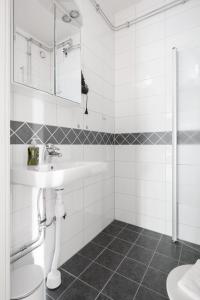 een witte badkamer met een wastafel en een toilet bij Cozy home in charming suburb in Sundbyberg +12 foto's