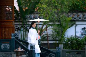 景洪市Naran manor的站在建筑物前拿着伞的妇女