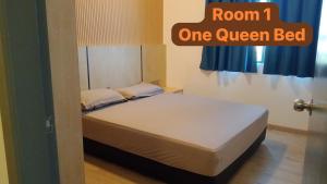 a bed in a room with a one queen bed at LC Paragon Apartment in Labuan