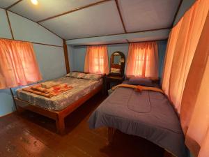 a small bedroom with two beds and a mirror at Koh Mak Green View Resort in Ko Mak