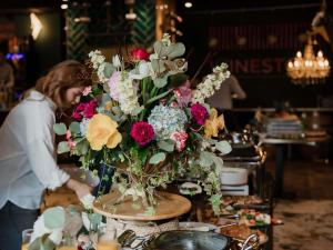 a woman is arranging a vase of flowers on a table at Mercure Timisoara in Timişoara