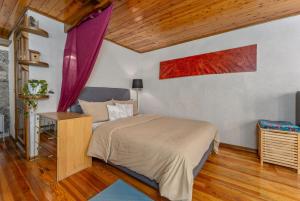 una camera da letto con un letto grande e un soffitto in legno di À Deux Pas ... a Briançon Altre 23 foto