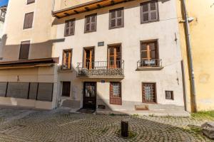 un grande edificio bianco con finestre e cortile di À Deux Pas ... a Briançon