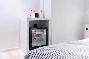 a small white room with a black refrigerator next to a bed at Chongqing Nanqing·World Time Hotel in Nan'an