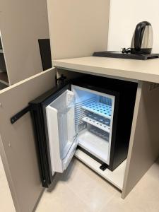 einem Kühlschrank mit offener Tür unter einer Theke in der Unterkunft Sunset Affittacamere in Cipollina