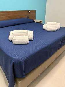 zwei Stapel Handtücher auf dem Bett in der Unterkunft Sunset Affittacamere in Cipollina