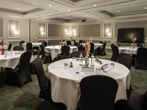 a conference room with tables and chairs and a flat screen tv at Maek Hotel Antwerp Central - Handwritten Collection in Antwerp