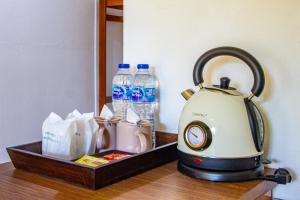 Ko Lanta YaiにあるLe Panpurie Koh Lanta Resortのお茶ポット、ボトル入り飲料水(テーブル上)