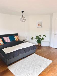 a bedroom with a bed and a potted plant at Big apartment surrounded by nature in Amsterdam in Ons Belang