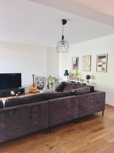 a large couch sitting in a living room at Big apartment surrounded by nature in Amsterdam in Ons Belang