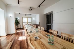 a long wooden table in a room with chairs and water bottles at OSW Sportowiec in Krynica Zdrój