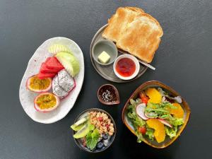 a table topped with plates of food and bread at Cheeva Dee Hotel in Chiang Mai