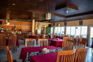 a restaurant with tables and chairs with red table cloth at Cemara Indah Hotel in Bromo