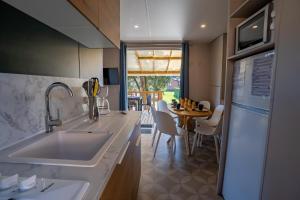Burnhaupt-le-HautにあるCamping Alsace Les Castorsのシンクとテーブルと椅子のあるキッチン +279枚の写真