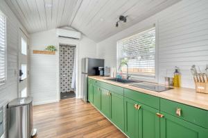 a kitchen with green cabinets and a refrigerator at Stay Portland - Noir-Emerald Modern TinyLux in Portland in Portland