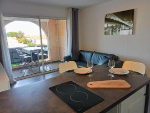 une cuisine avec une table, des verres à vin et un canapé dans l'établissement studio à 100m de la plage et de la piscine, à Cervione