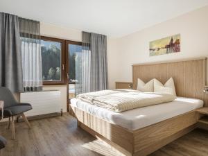 フィンケンベルクにあるAppartementhaus Sennhüttnの大きなベッドと窓のある寝室
