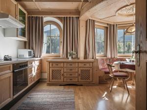フィンケンベルクにあるAppartementhaus Sennhüttnのキッチン(木製キャビネット、ダイニングルーム付きのテーブル付)
