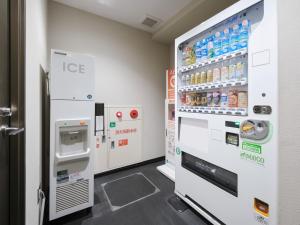 Una máquina expendedora en una tienda con bebidas en la pared. en Villa Fontaine Tokyo Hibiya, en Tokio