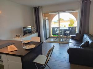 un salon avec un canapé et une table avec des chaises dans l'établissement studio à 100m de la plage et de la piscine, à Cervione