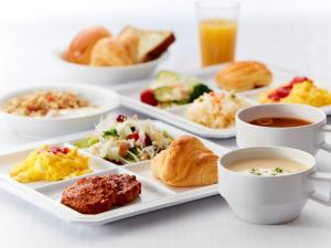 una mesa con platos de comida y tazas de café en Villa Fontaine Tokyo Hibiya, en Tokio