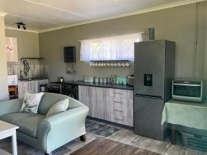 a living room with a couch and a refrigerator at Protea cottage in Wildernis