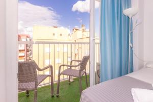 a bedroom with two chairs and a balcony with a view at Hotel Boogaloo - Adults Only in El Arenal