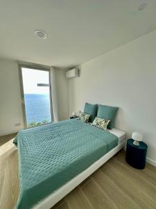 una camera da letto con un letto grande con una grande finestra di Casa Favelas, Vue Mer et Proche de Monaco a Cap d'Ail Altre 31 foto