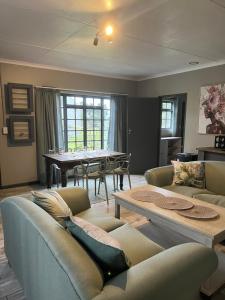 a living room with a couch and a table at Protea cottage in Wildernis