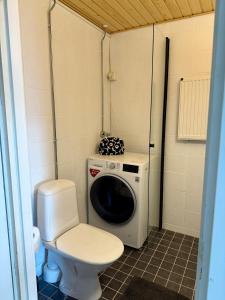 a small bathroom with a toilet and a washing machine at Beautiful home in the center of Rovaniemi in Rovaniemi