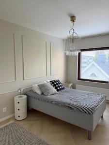 a bedroom with a bed and a window and a chandelier at Beautiful home in the center of Rovaniemi in Rovaniemi