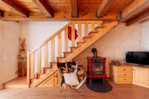 a room with a staircase with a chair and a stove at Macrillo Guest House in Gallio