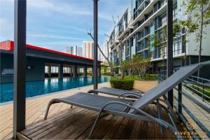 a pair of chairs sitting on a deck next to a swimming pool at KIP Core Soho Suite by Five Senses in Sepang