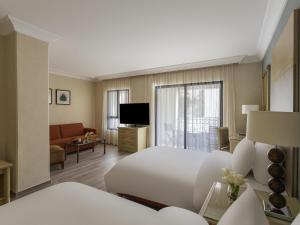 a hotel room with a bed and a living room at Mövenpick Resort Petra in Wadi Musa +233 photos