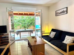 a living room with a couch and a table at Le Cersois,proche Canal du Midi et de la Mer, environnement paisible et parking privé in Cers