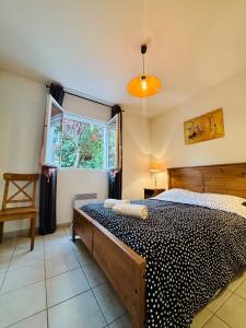 a bedroom with a bed and a window at Le Cersois,proche Canal du Midi et de la Mer, environnement paisible et parking privé in Cers