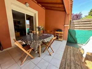 a dining table and chairs on a patio at Le Cersois,proche Canal du Midi et de la Mer, environnement paisible et parking privé in Cers