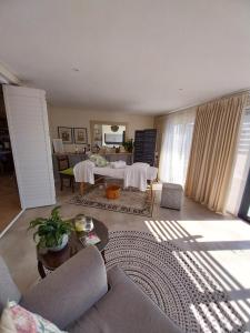 a living room with a couch and a table at White Feather Wellness Room and Beauty Spa in Yzerfontein