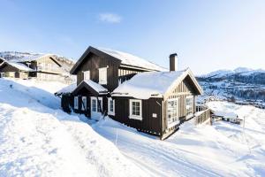 una cabaña de troncos en la nieve con nieve en Rauland Feriesenter, en Rauland
