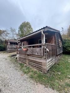 a wooden cabin with a porch on the grass at chalet montana 4_4pers in Roquefeuil