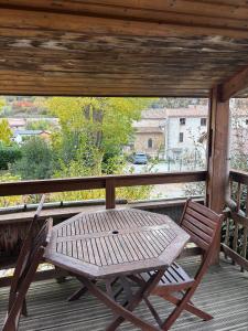 a wooden table and chair sitting on a porch at Chalet montana 3- 4pers in Roquefeuil